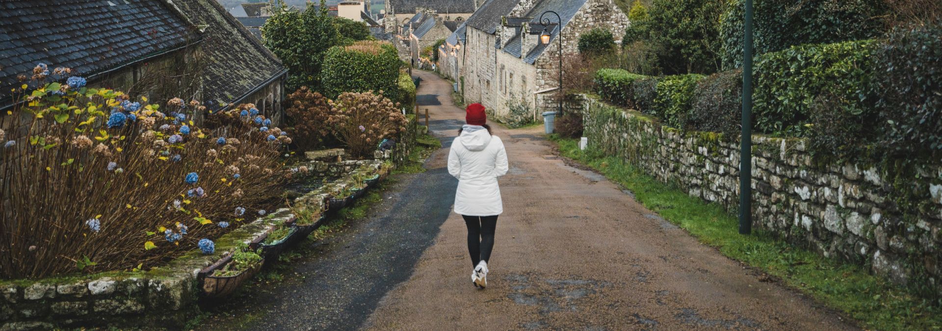 Une jeune femme se promène à Locronan en hiver