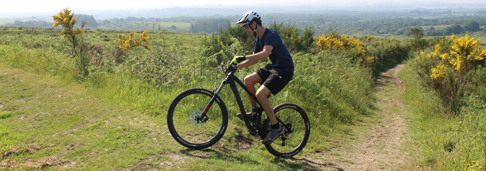 Pratique du VTT dans les Monts d’Arrée sur un chemin au milieu de la lande en été