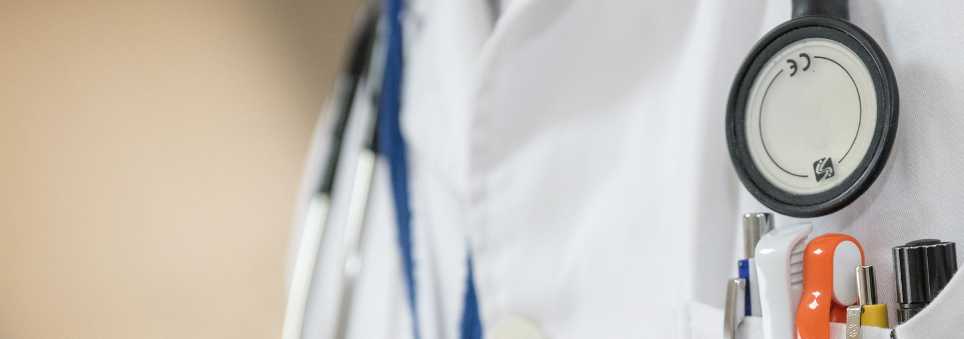 Stéthoscope et stylos dans la poche d’une blouse de professionnel de santé.