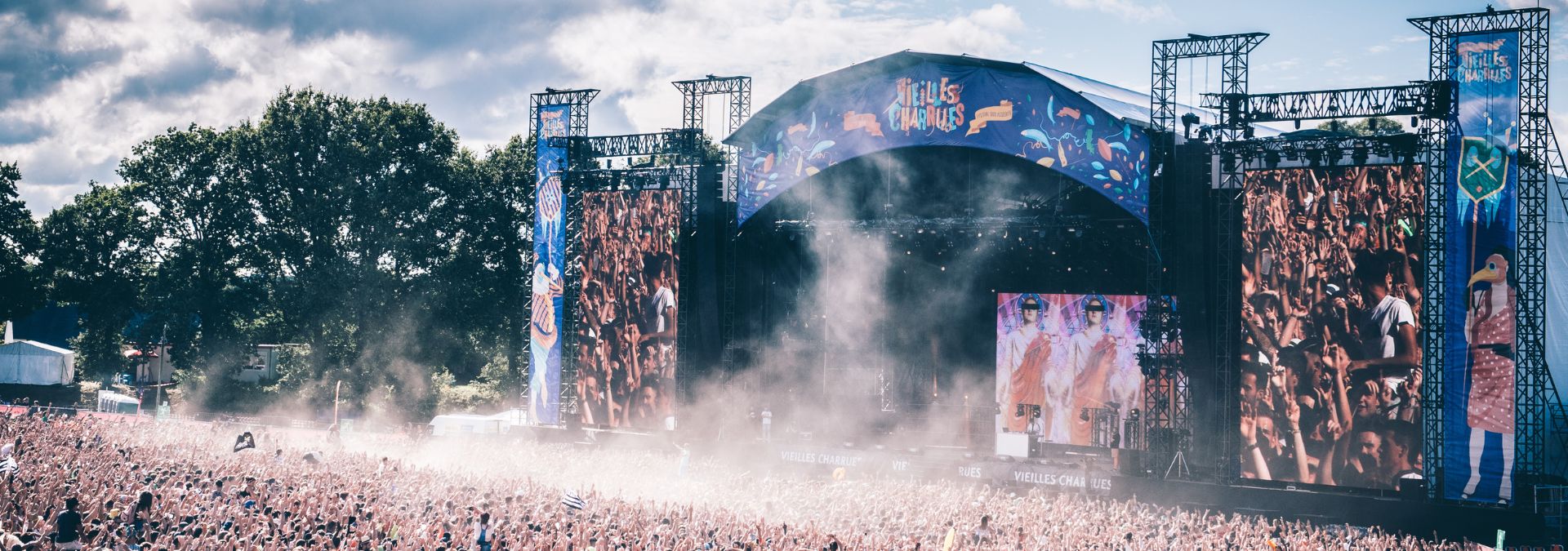 Foule immense devant la grande scène du festival des Vieilles Charrues à Carhaix, avec écrans géants et ambiance festive