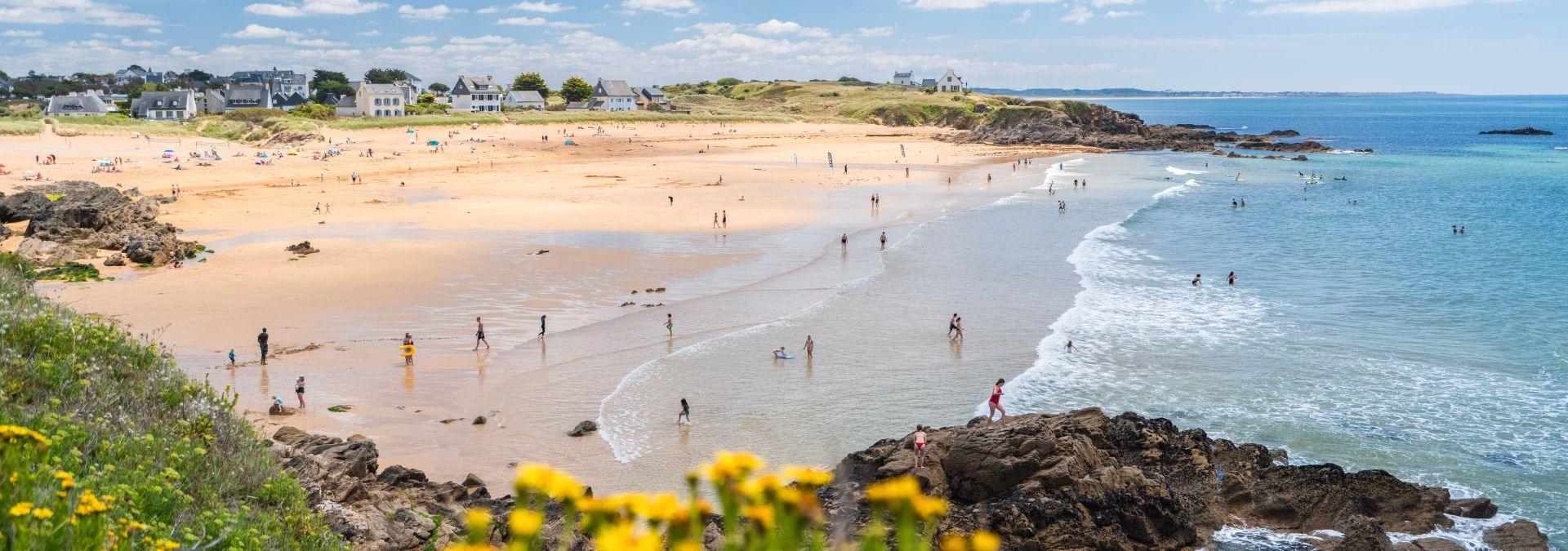 Vue en hauteur de la plage de Bellangenêt avec sable fin, rochers et baigneurs dans le Finistère.