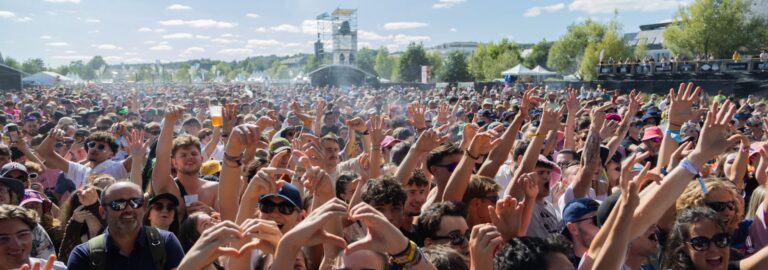 Nombreux festivaliers souriants, les bras levés, pendant la Fête du Bruit dans Landerneau.