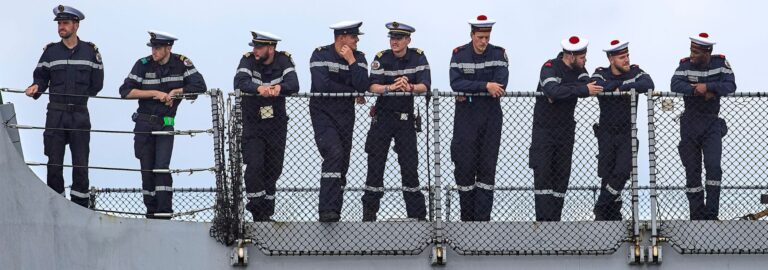 Marins en uniforme de la Marine nationale regroupés sur le pont d'un bâtiment militaire à Brest, dans le Finistère.