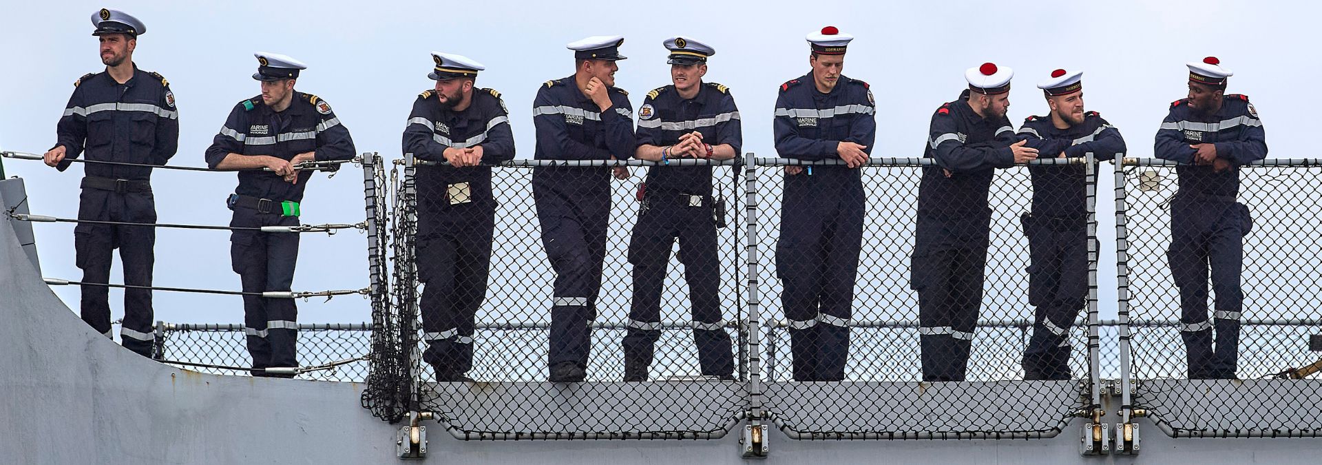 Marins en uniforme de la Marine nationale regroupés sur le pont d'un bâtiment militaire à Brest, dans le Finistère.