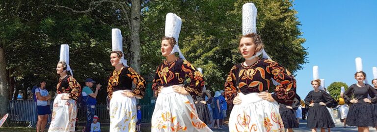 Femmes en costume traditionnel bigouden et coiffes brodées défilant lors du Festival des Brodeuses à Pont-l'Abbé, dans le Finistère.