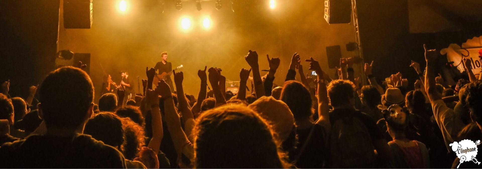 Public les bras levés devant un groupe en concert au Festival L’Ilophone sur l’île d’Ouessant.